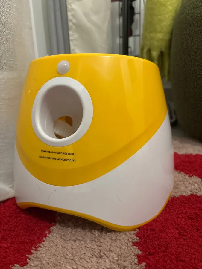 Le lanceur jaune posé sur un tapis à motifs